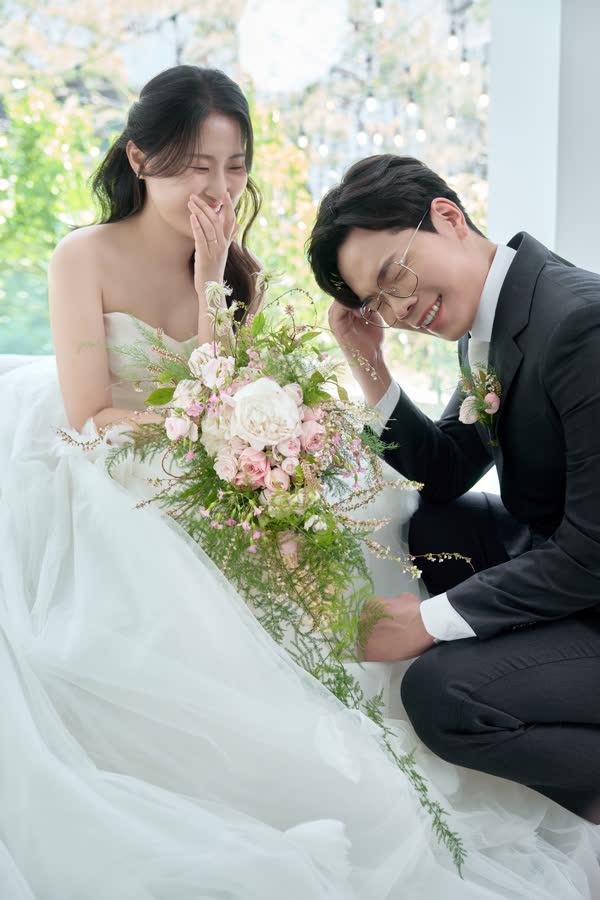 부케를 사이에 두고 웃는 신랑 신부