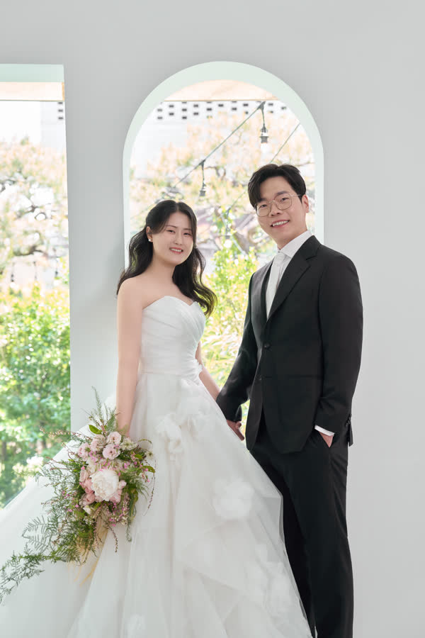 아치 창가에서 손을 잡은 신랑 신부
